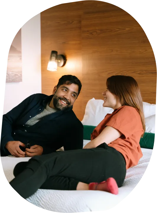 A couple lounging on a bed in a hotel room