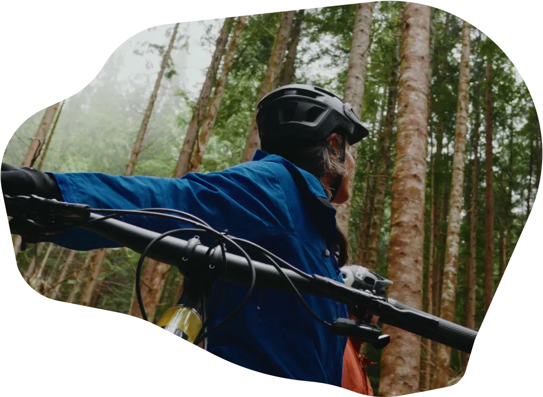 Three women sitting around a campfire on a rocky beach near the water