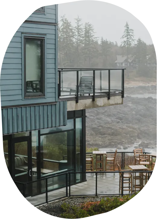 Exterior view of a building with a patio and balcony overlooking the ocean